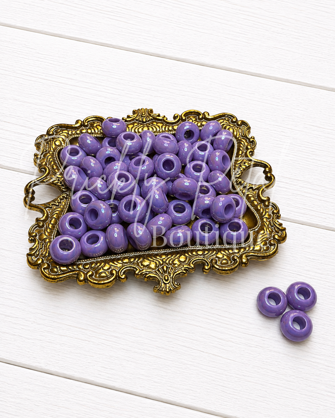 purple european large hole beads on gold tray against white background