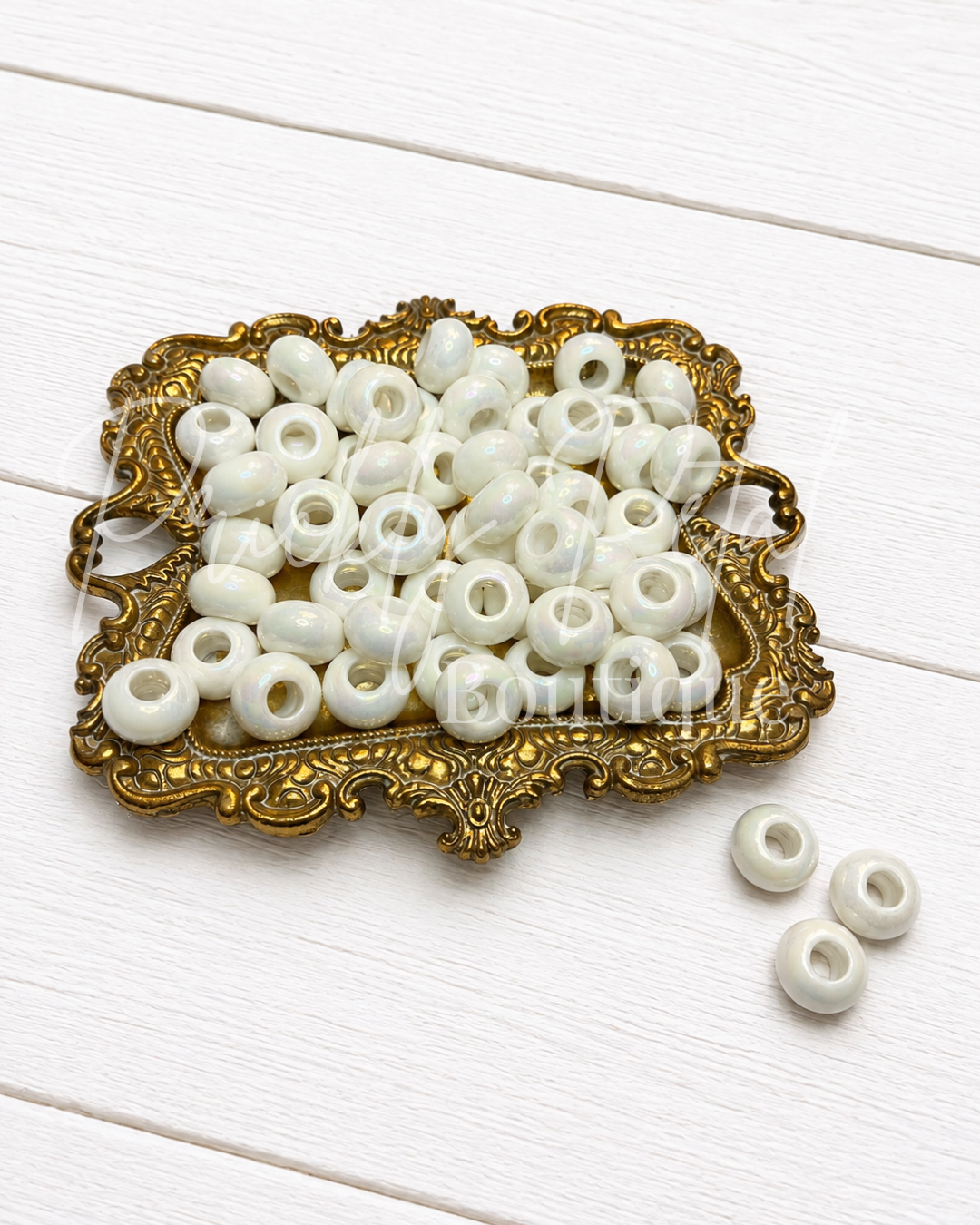 white european large hole beads on gold tray against white background