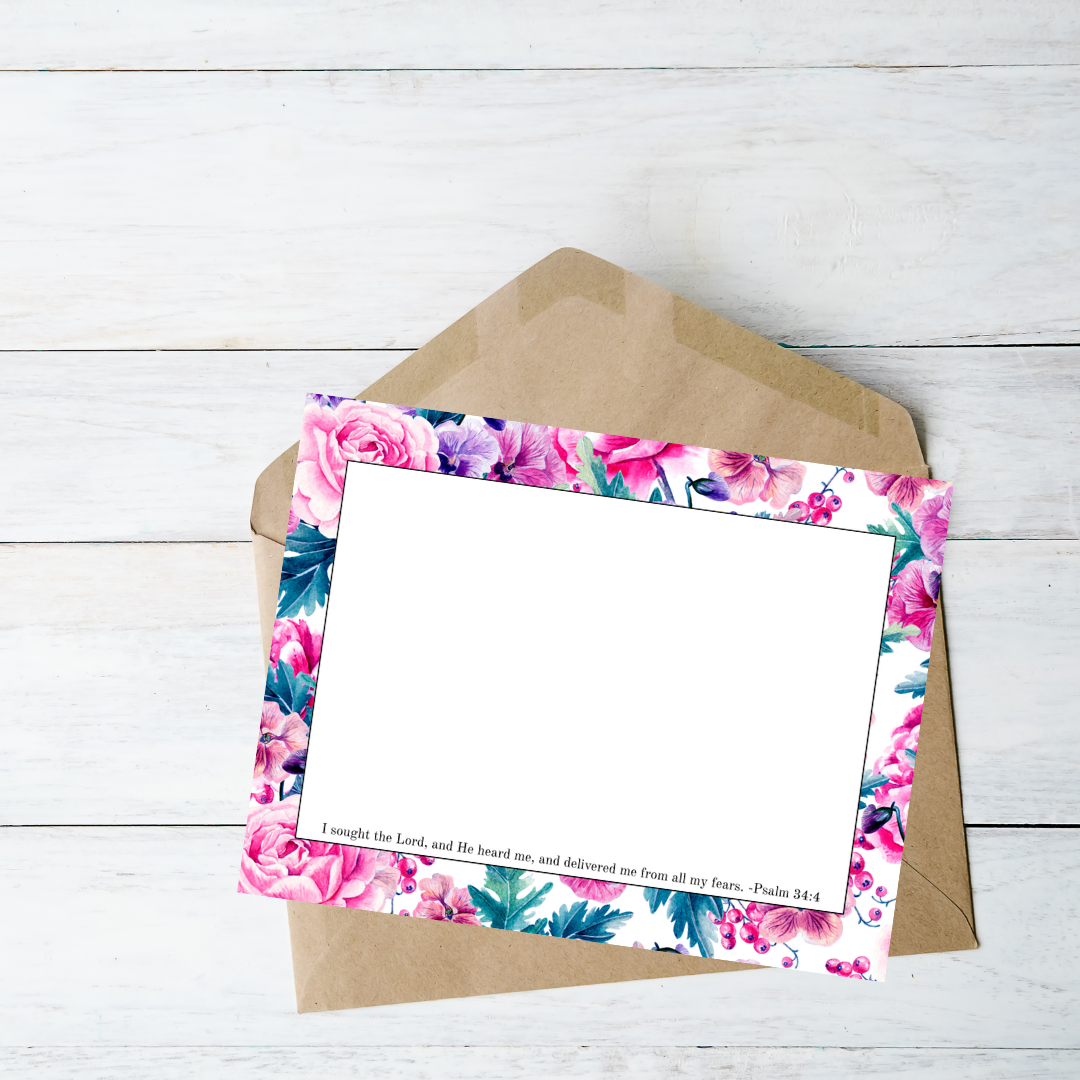 Floral card with a brown envelope on a light wooden surface