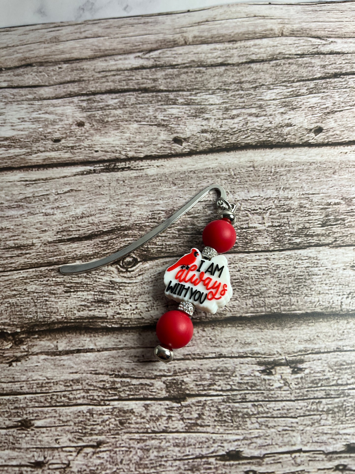 Beaded bookmark with heart-shaped charm on a wooden surface