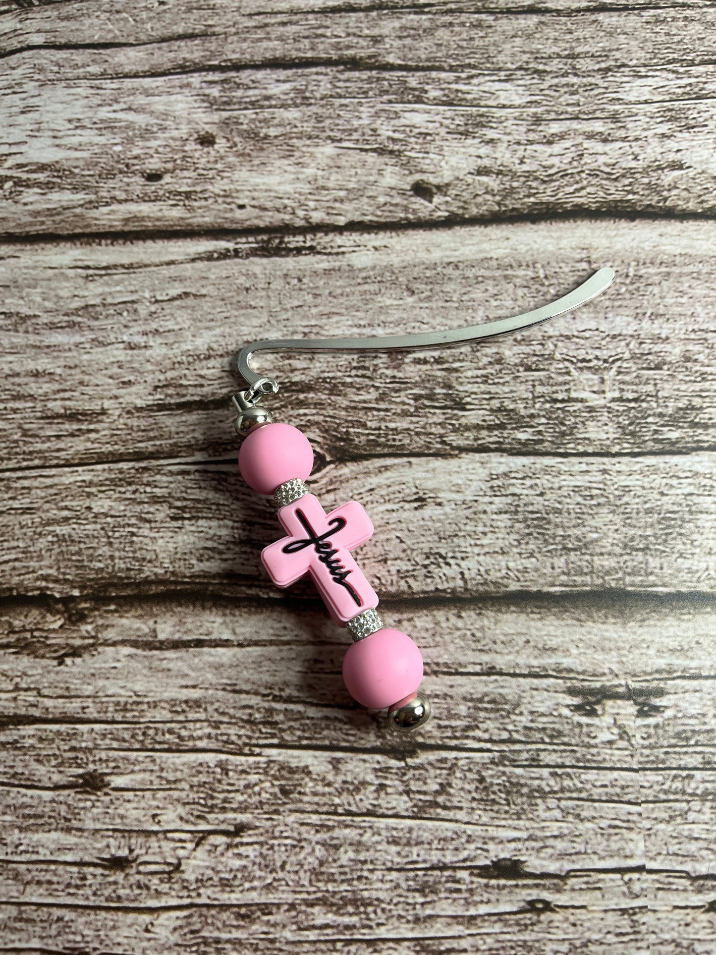 Pink beaded bookmark on a wooden surface