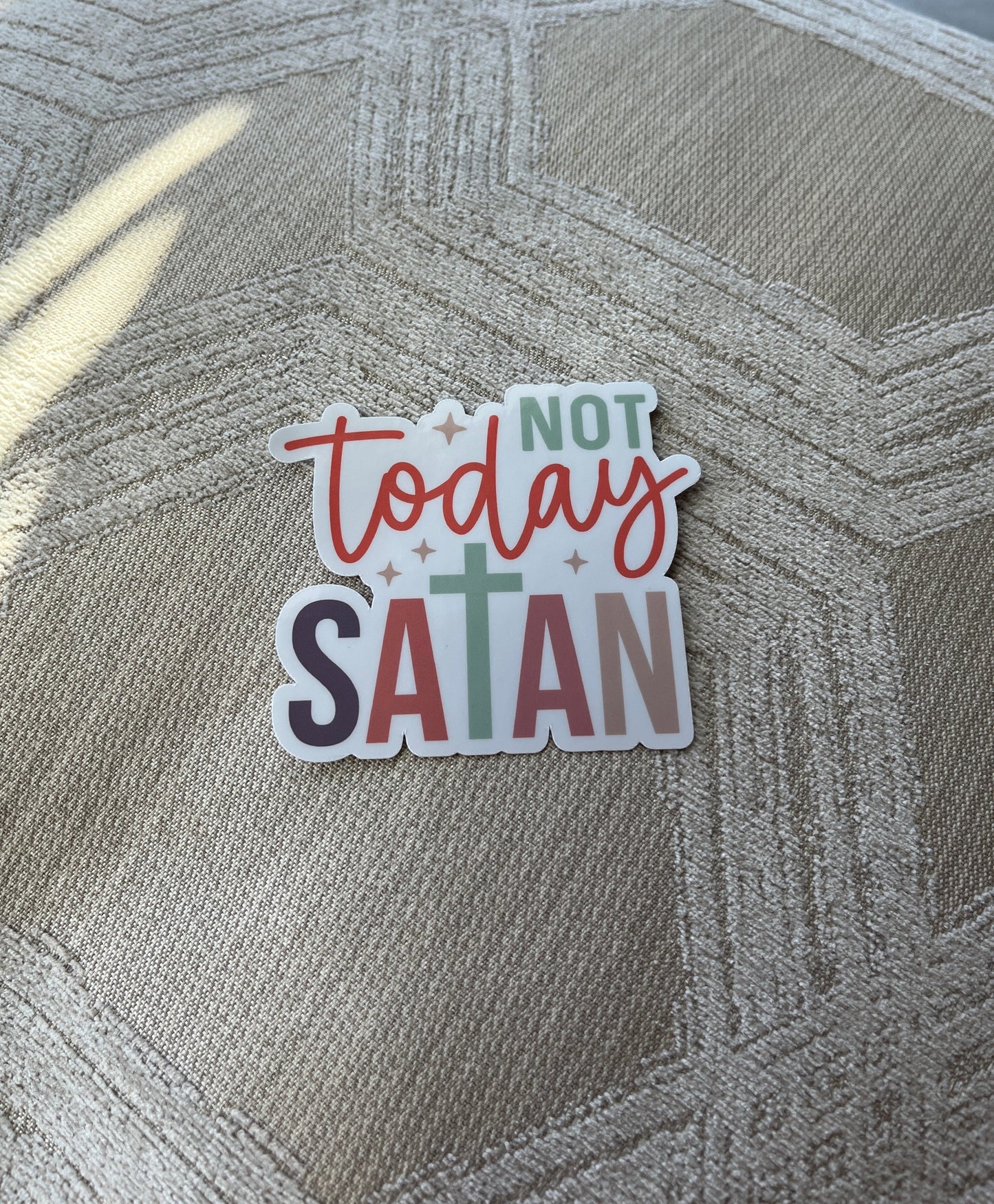 Sticker with 'Not today Satan' text on a textured surface