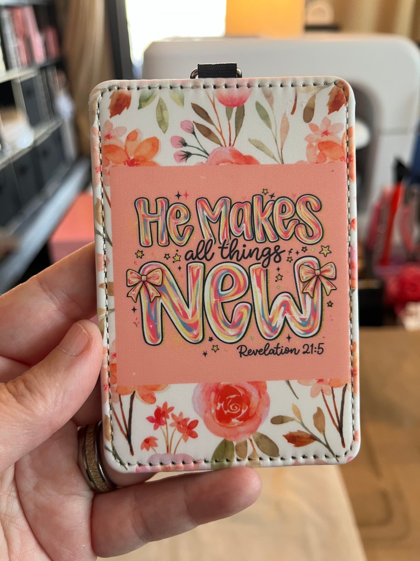 Floral-patterned cardholder with text held by a hand