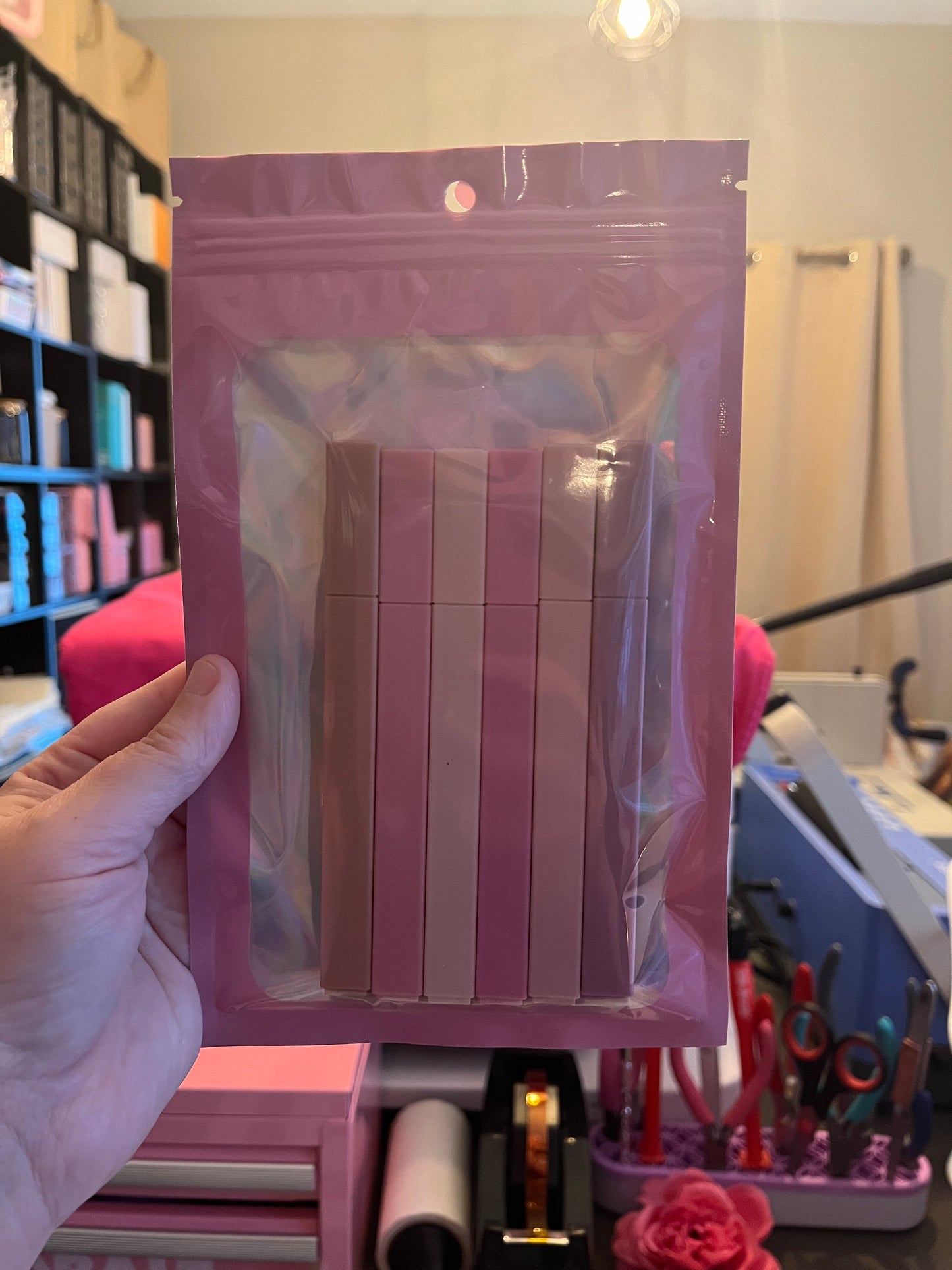 Hand holding a pink bible highlighters with a blurred background