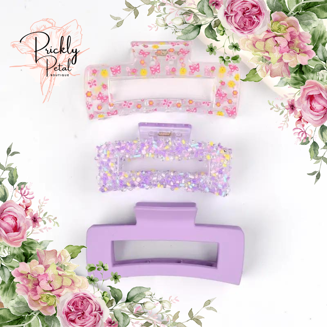 A set of hair clips with a floral design, predominantly in shades of pink and purple, presented on a white background with floral illustrations.