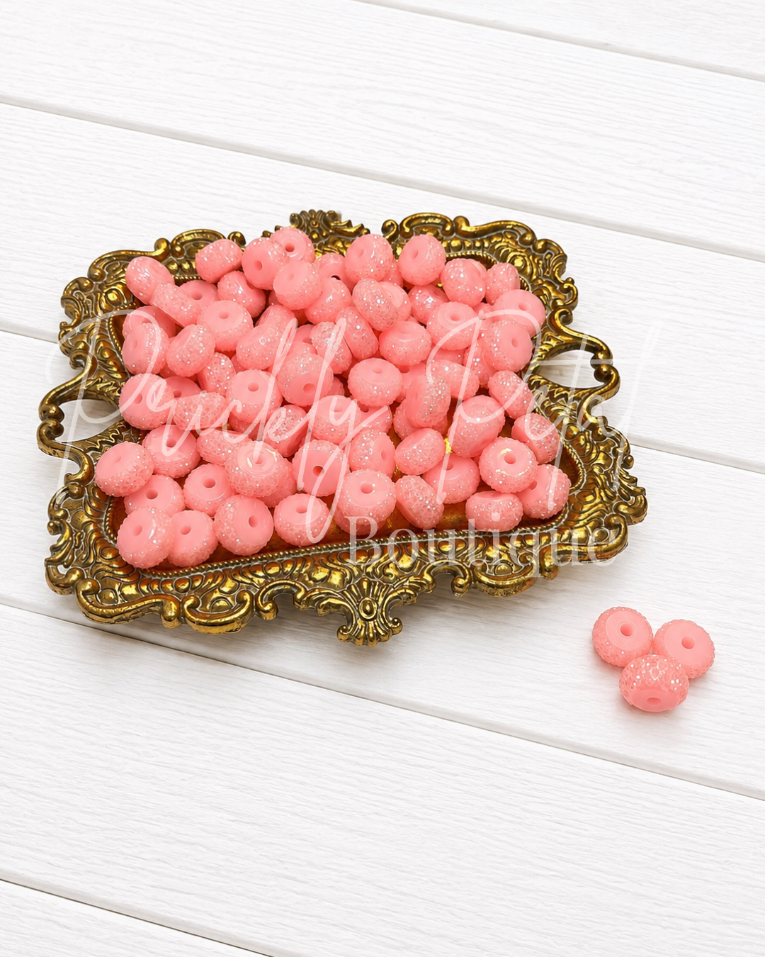 blush sparkle beads on gold tray against white wood
