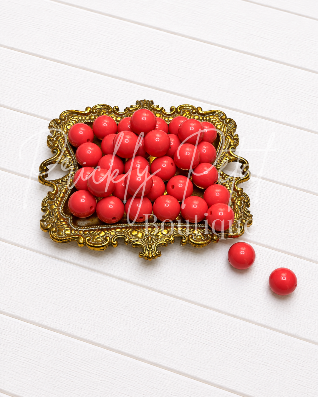 16mm round acrylic beads on gold tray against white background