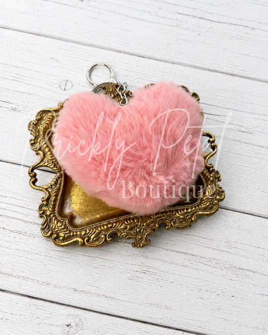 fur heart keychain on gold tray on white wood