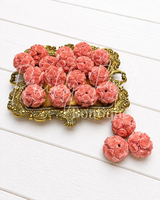 coral rose bouquet bead on gold tray against white wood background