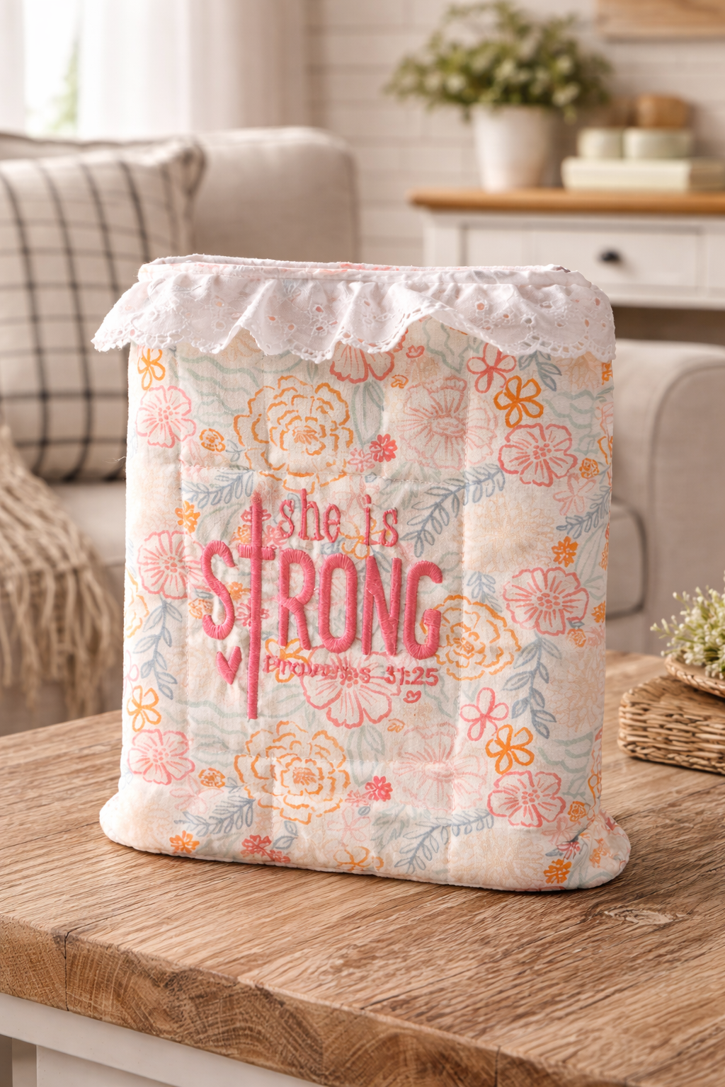 embroidered bible sleeve with floral design and 'she is strong' text on a wooden surface.