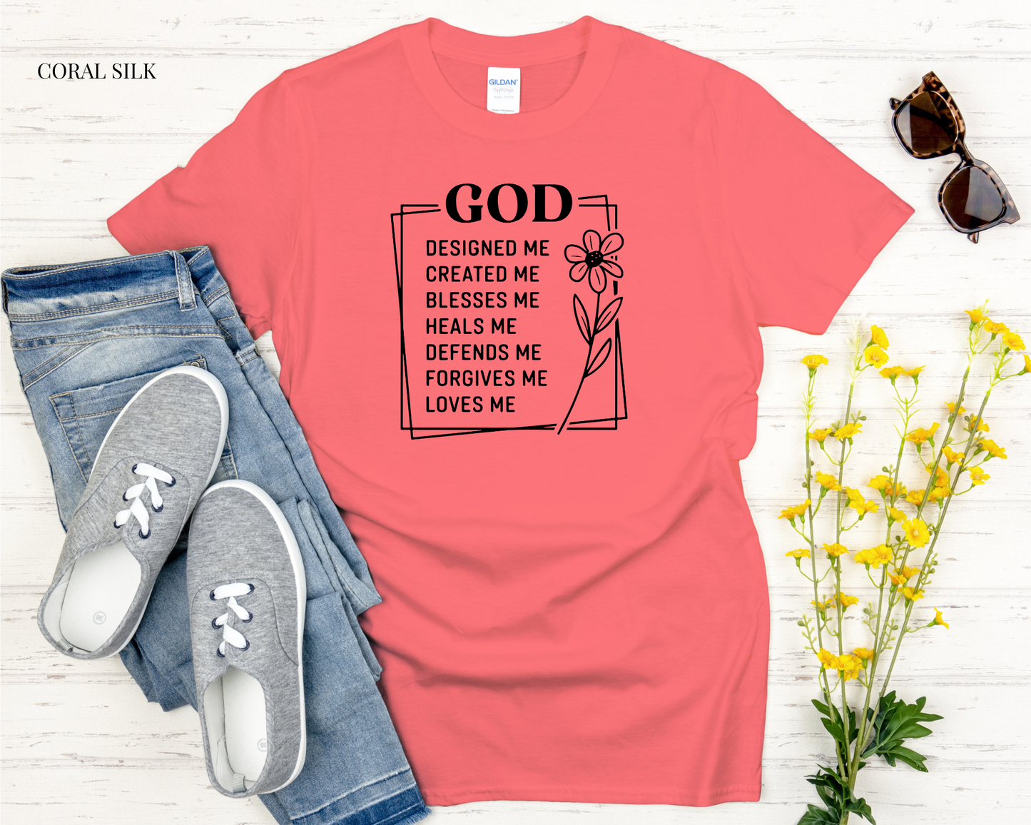 Coral t-shirt with motivational quote, jeans, sneakers, and flowers on a white background