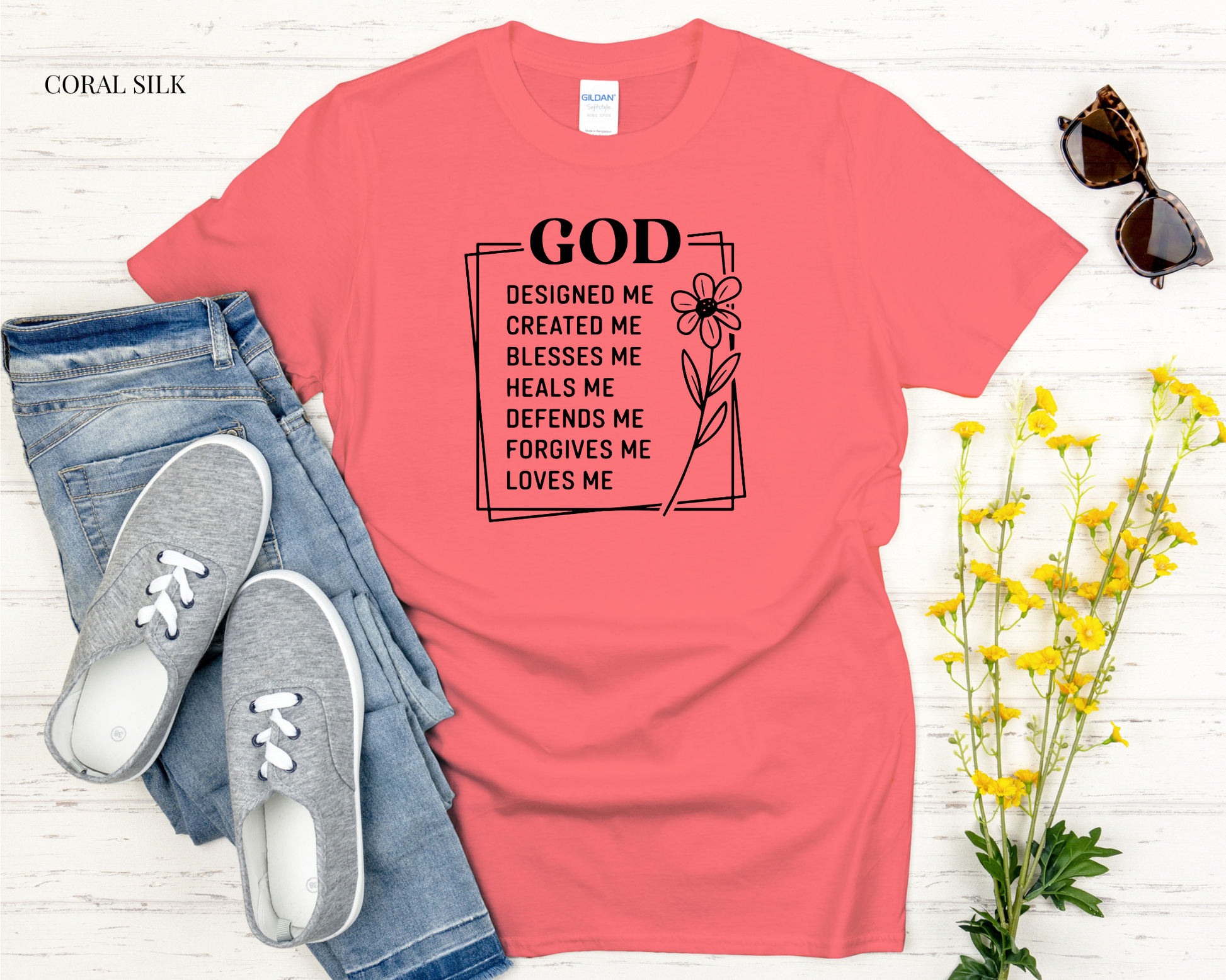 Coral t-shirt with motivational quote, jeans, sneakers, and flowers on a white background