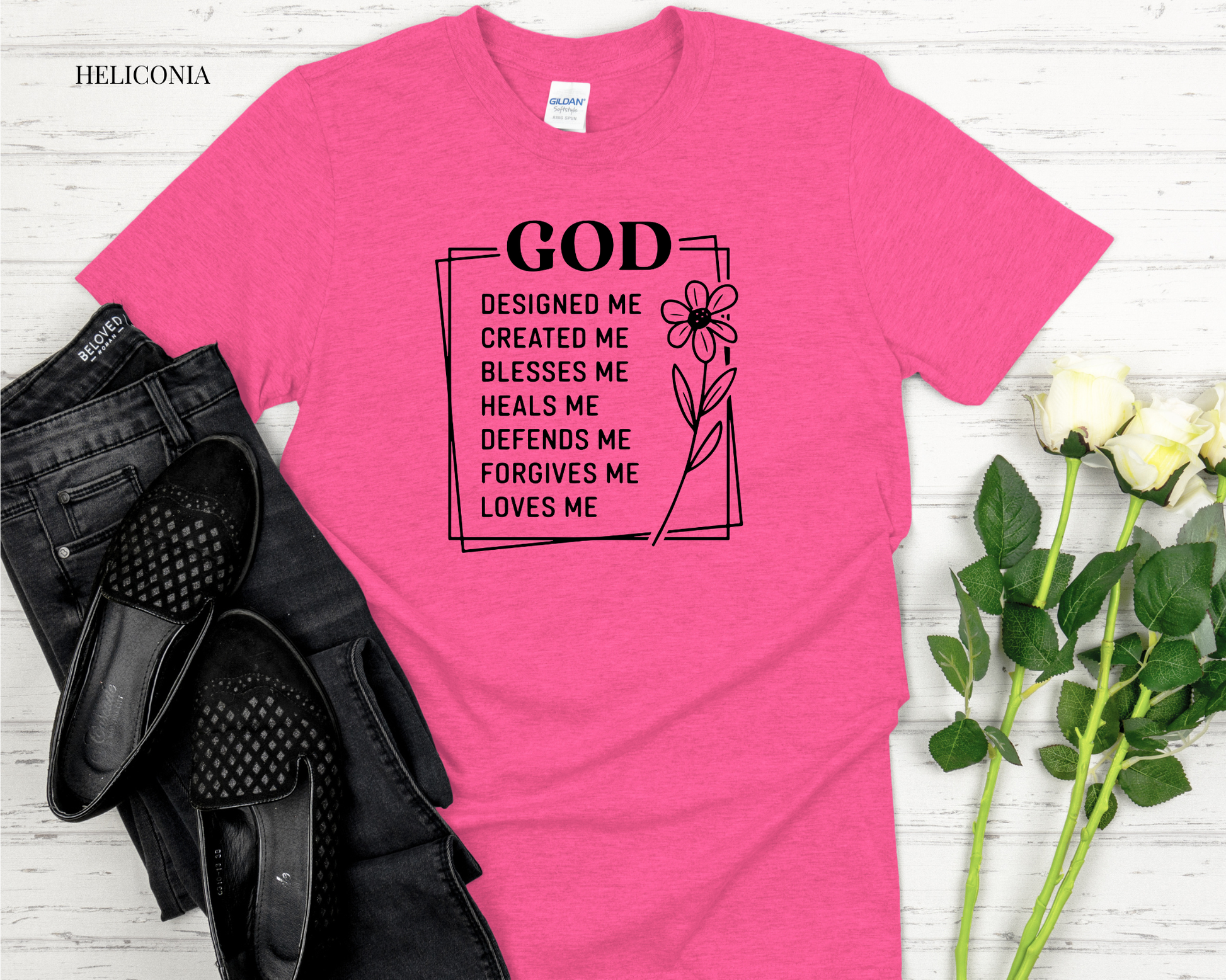 Pink t-shirt with motivational quote on a wooden surface with shoes and flowers.