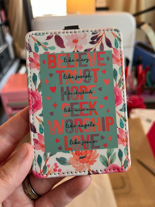Floral patterned cardholder with motivational text held by a hand