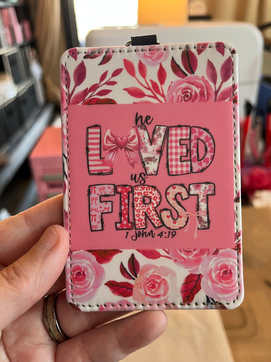 Pink cardholder with floral design and text held by a hand