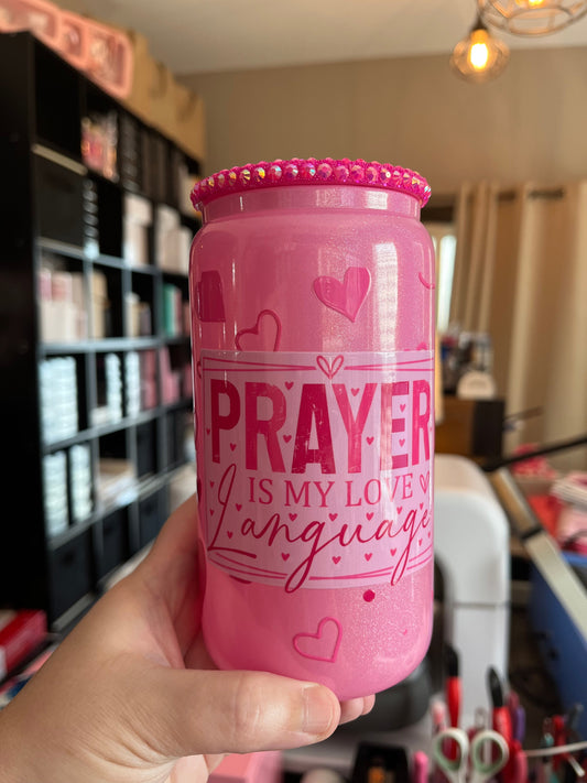 Pink water bottle with text held by a hand in an indoor setting
