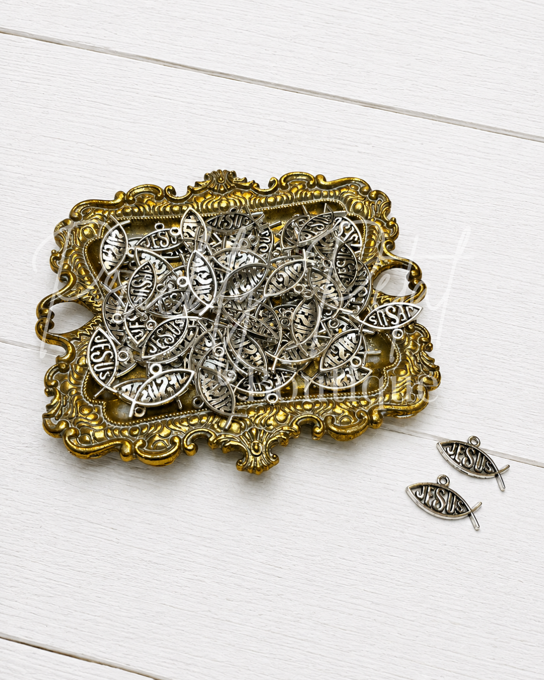 Jesus fish pendant on gold tray against white background