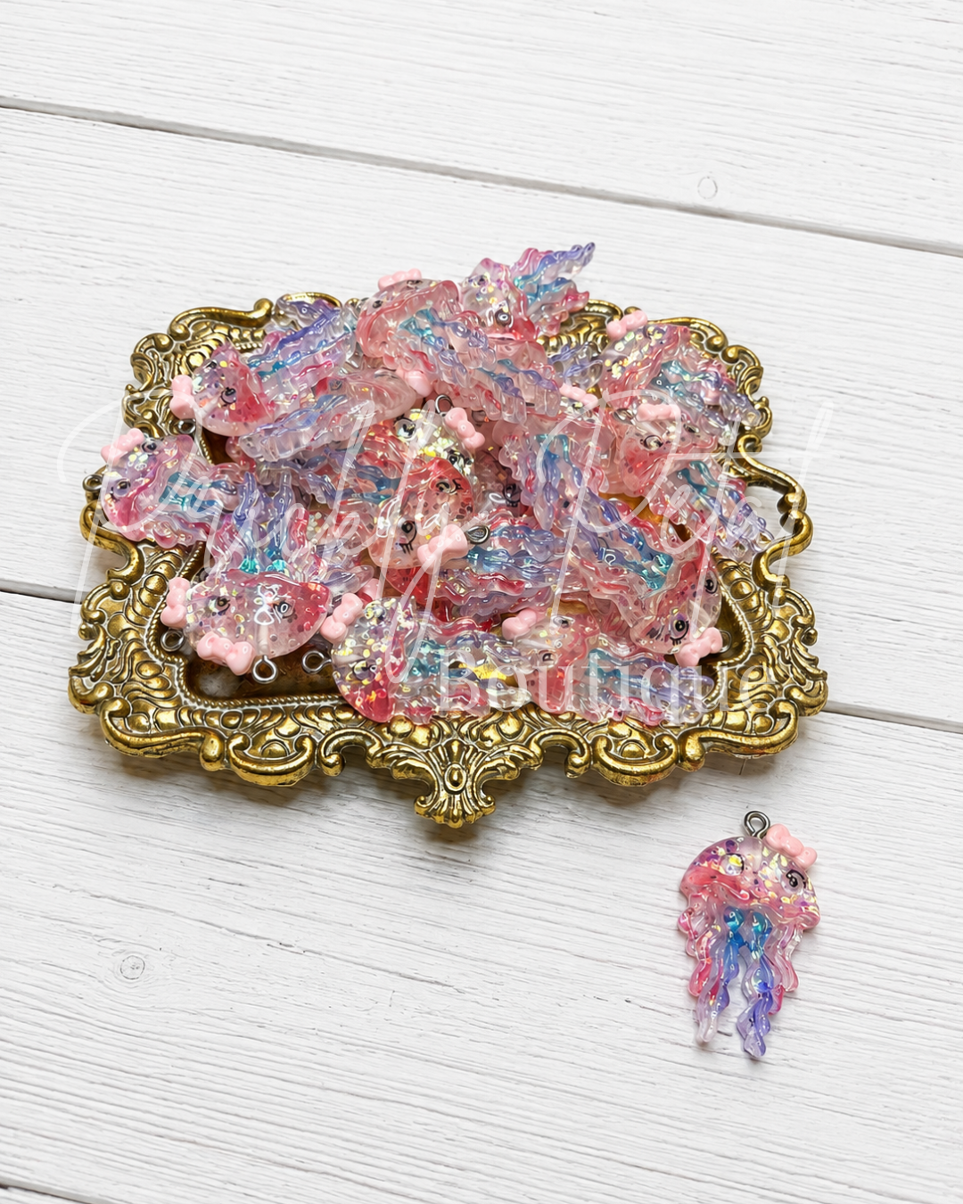 jellyfish pendant charm on gold tray against white background