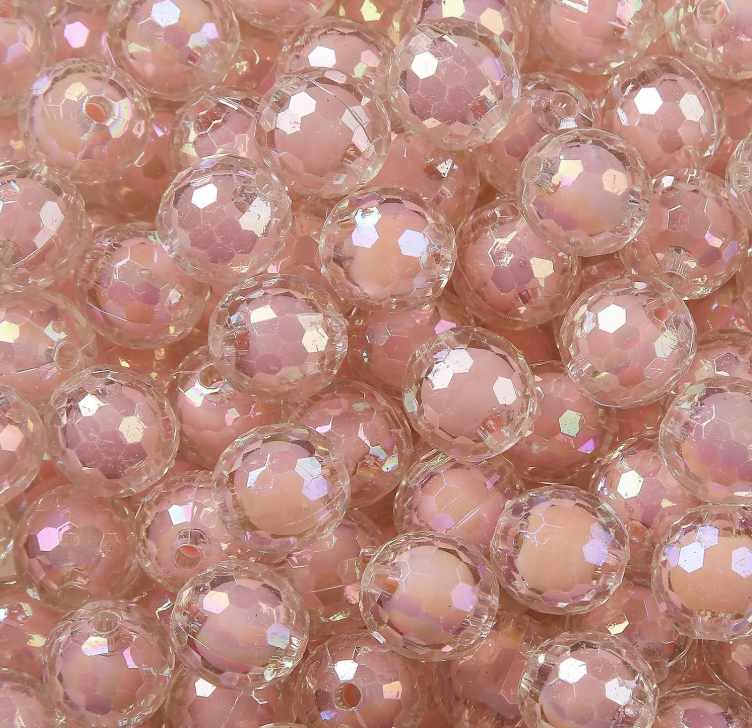 Close-up of pink and clear bubble-like beads with iridescent sheen.