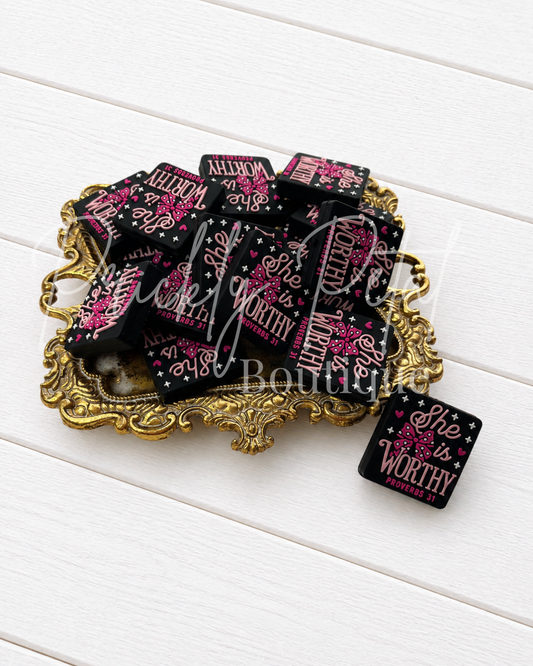 She is worthy-Proverbs 31 silicone focal beads and decorated with pink floral and heart motifs, displayed on an ornate gold tray over a white wood background.