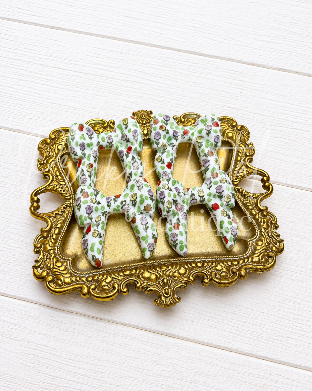silicone bows on gold tray against white background