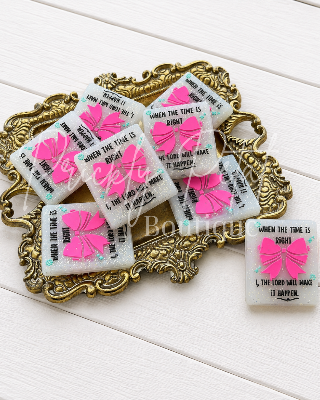 Six rectangular beads with pink bows and inspirational text are arranged on an ornate gold tray, with one soap placed beside it on a white wood background. A semi-transparent 'CK Boutique' watermark is visible across the center.
