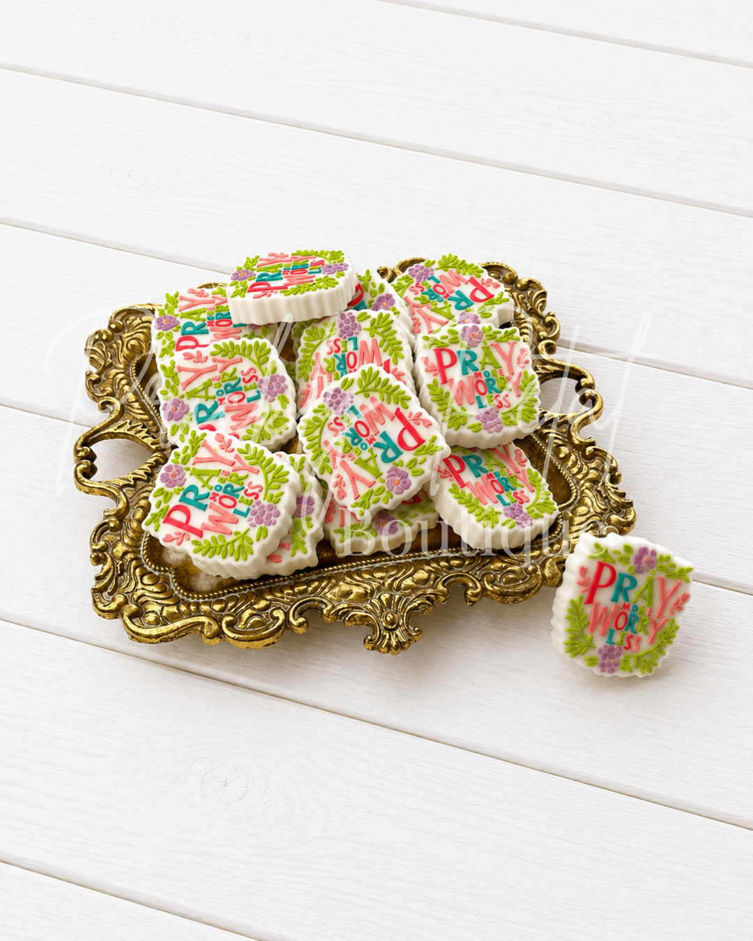 silicone focal bead arranged on an ornate gold tray on a white wooden background.
